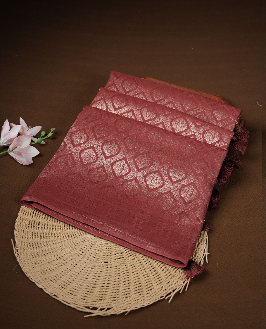 Chocolate brown colour banaras satin crepe saree featuring gold zari pattern across body, with self colour border with gold zari pattern and paired with matching blouse.