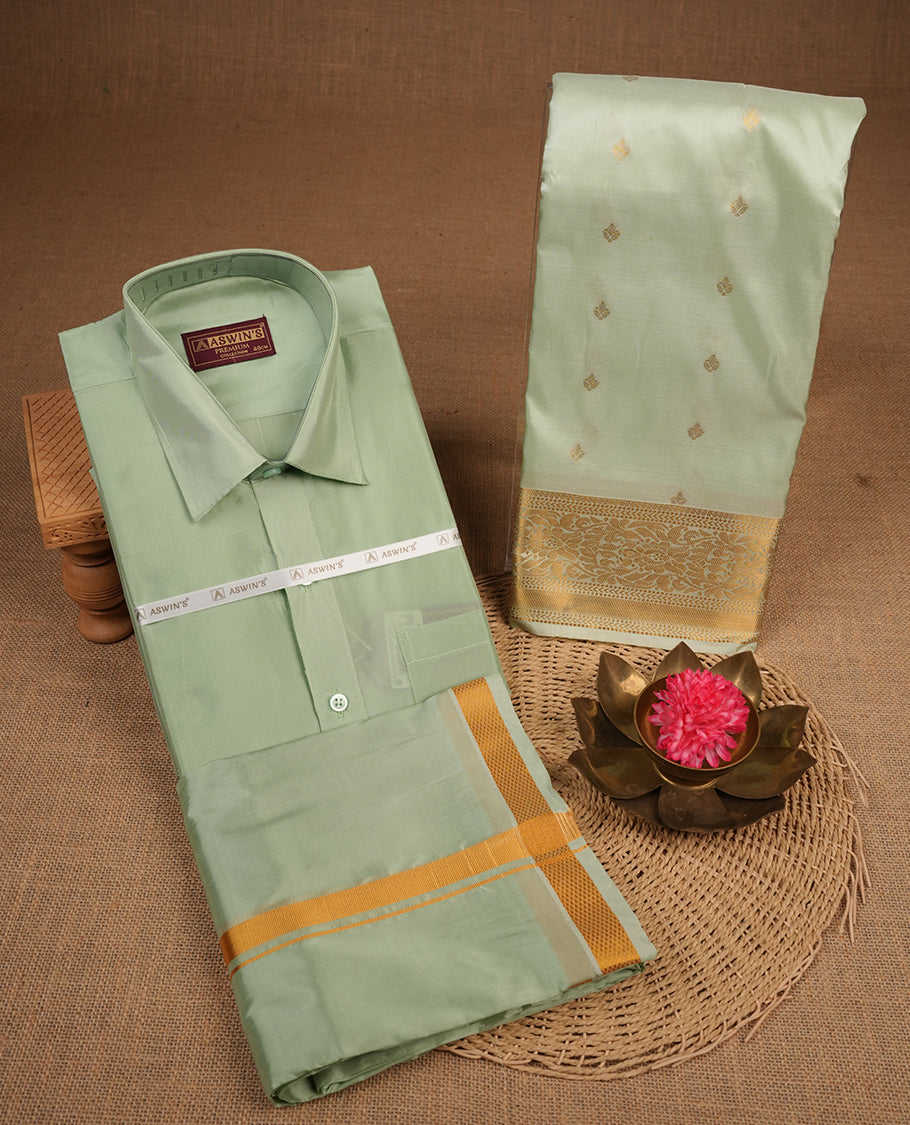 Pista colour shirt and dhoti with gold colour border, paired with matching colour silk saree featuring gold zari buttas and traditional border paired with matching blouse piece.