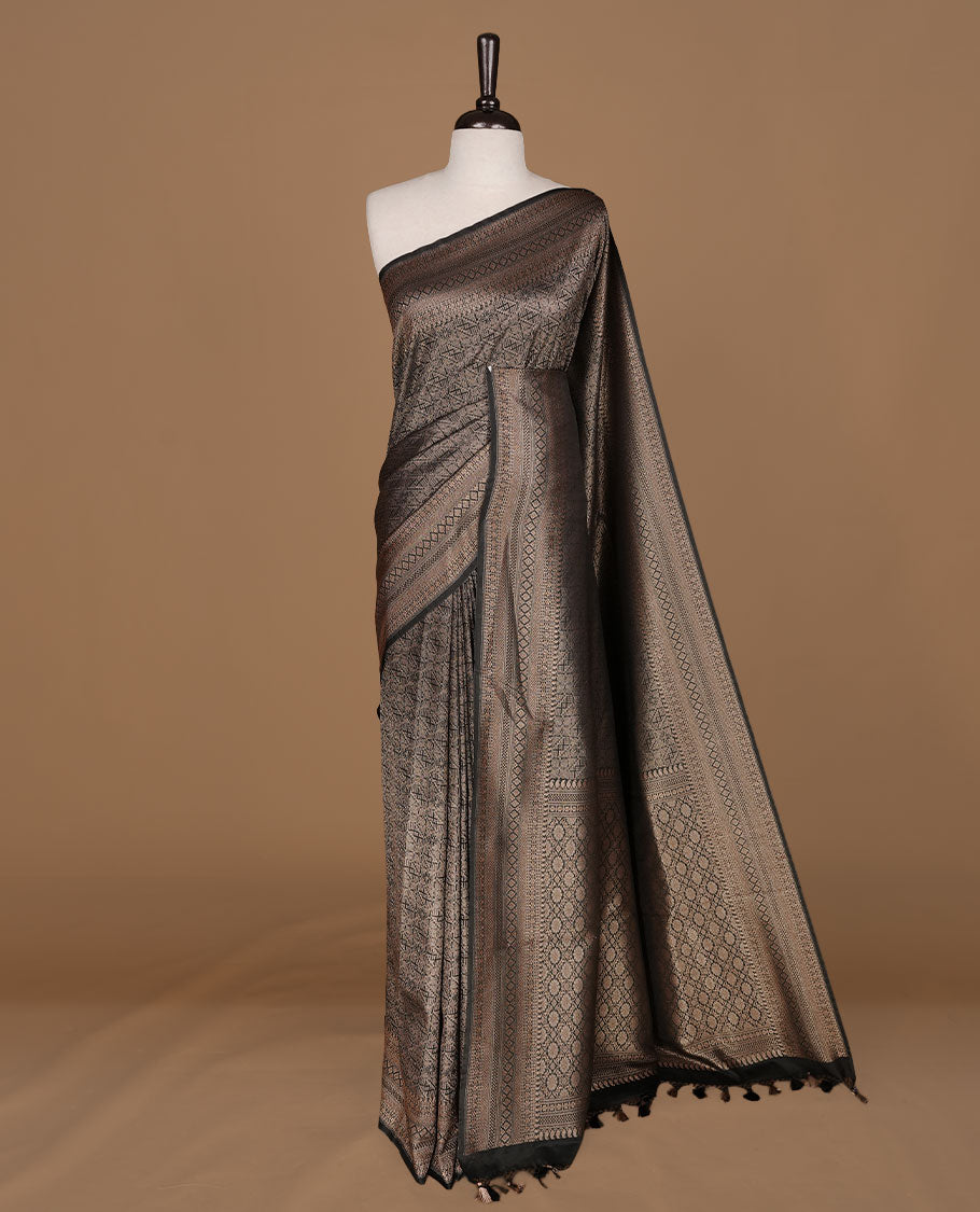 Black colour semi banaras katan saree featuring Gold zari Pattern across body, complemented by self colour with zari border, paired with matching blouse piece.