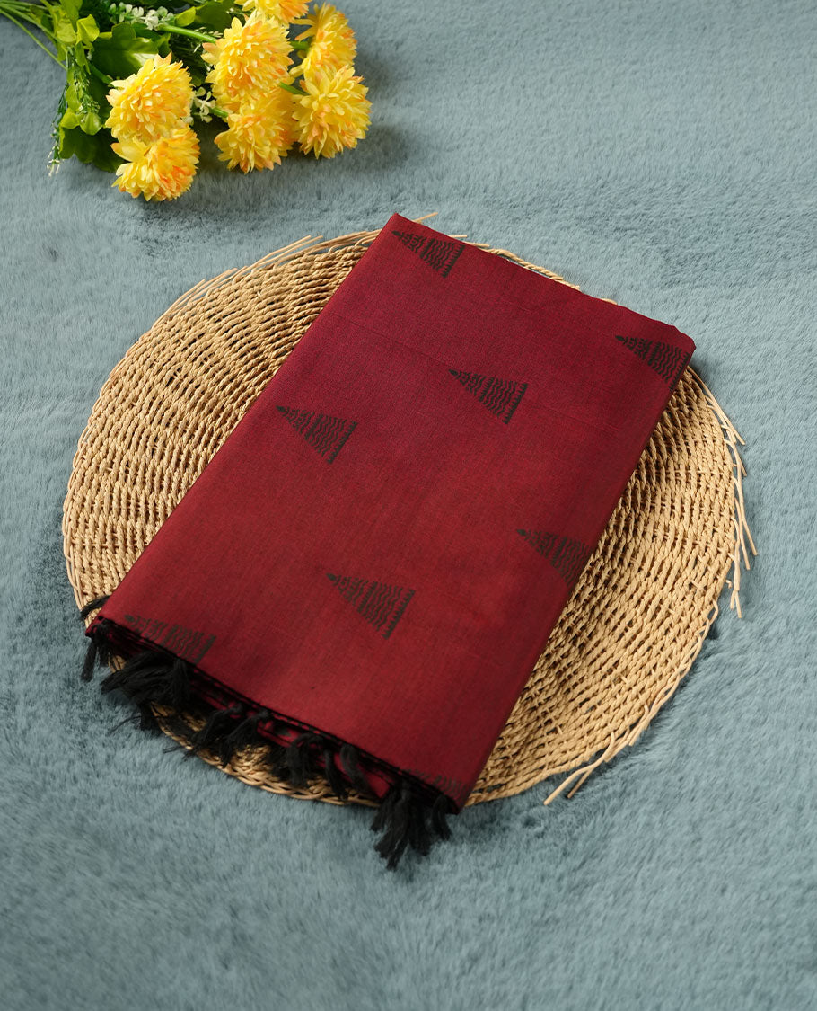 Dark red colour poly cotton saree with black temple motifs on the body, paired with a matching with black woven traditional border, and a coordinated all‑over geometric printed blouse piece.