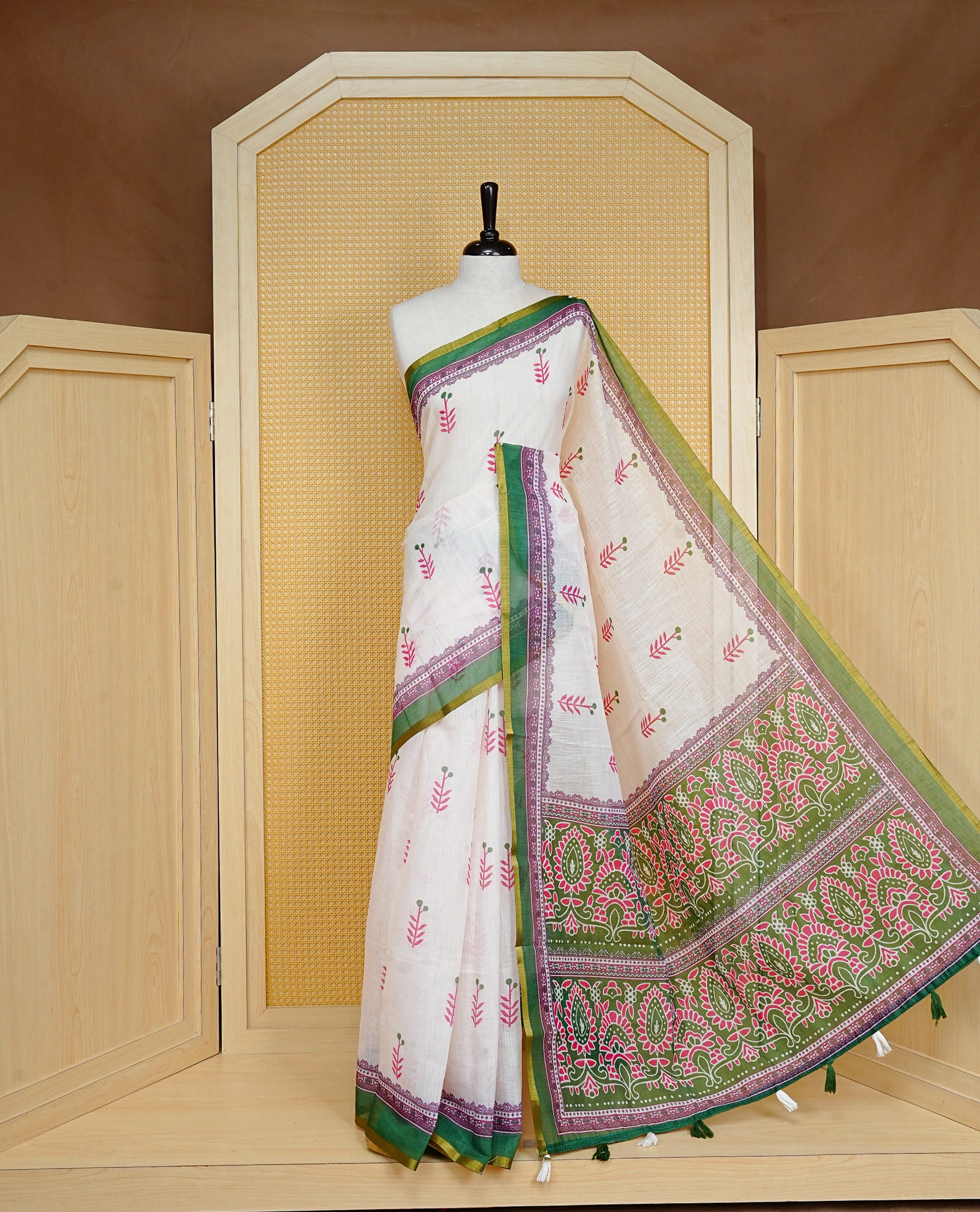 Off White colour Semi Linen Saree Featuring Elegant Floral Print on body, Contrast Green Colour Border, Minimal Floral print Pallu, Unique Tassel Detailing For Festive Vibe, Contrast Colour Blouse piece.