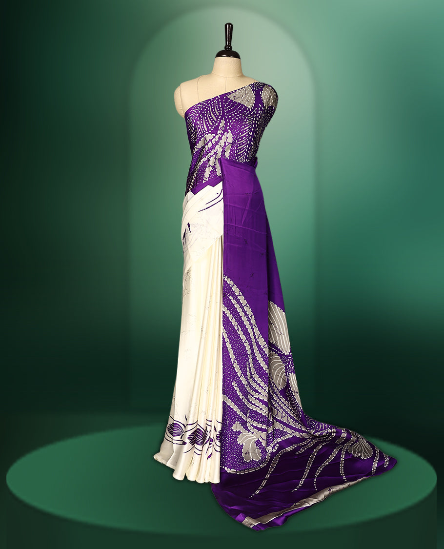 Purple colour Semi Modal saree featuring artistic abstract prints across the body, beautifully contrasted with Off White highlights, complemented by a bold patterned pallu, and paired with a matching blouse