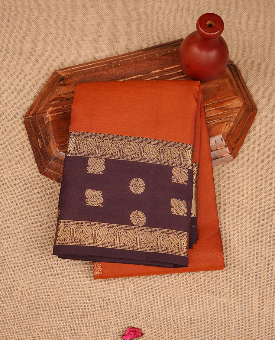 Brick red colour Vasundhara silk saree featuring zari motifs on body, complemented by contrast coffee brown colour with zari buttas border, paired with matching.