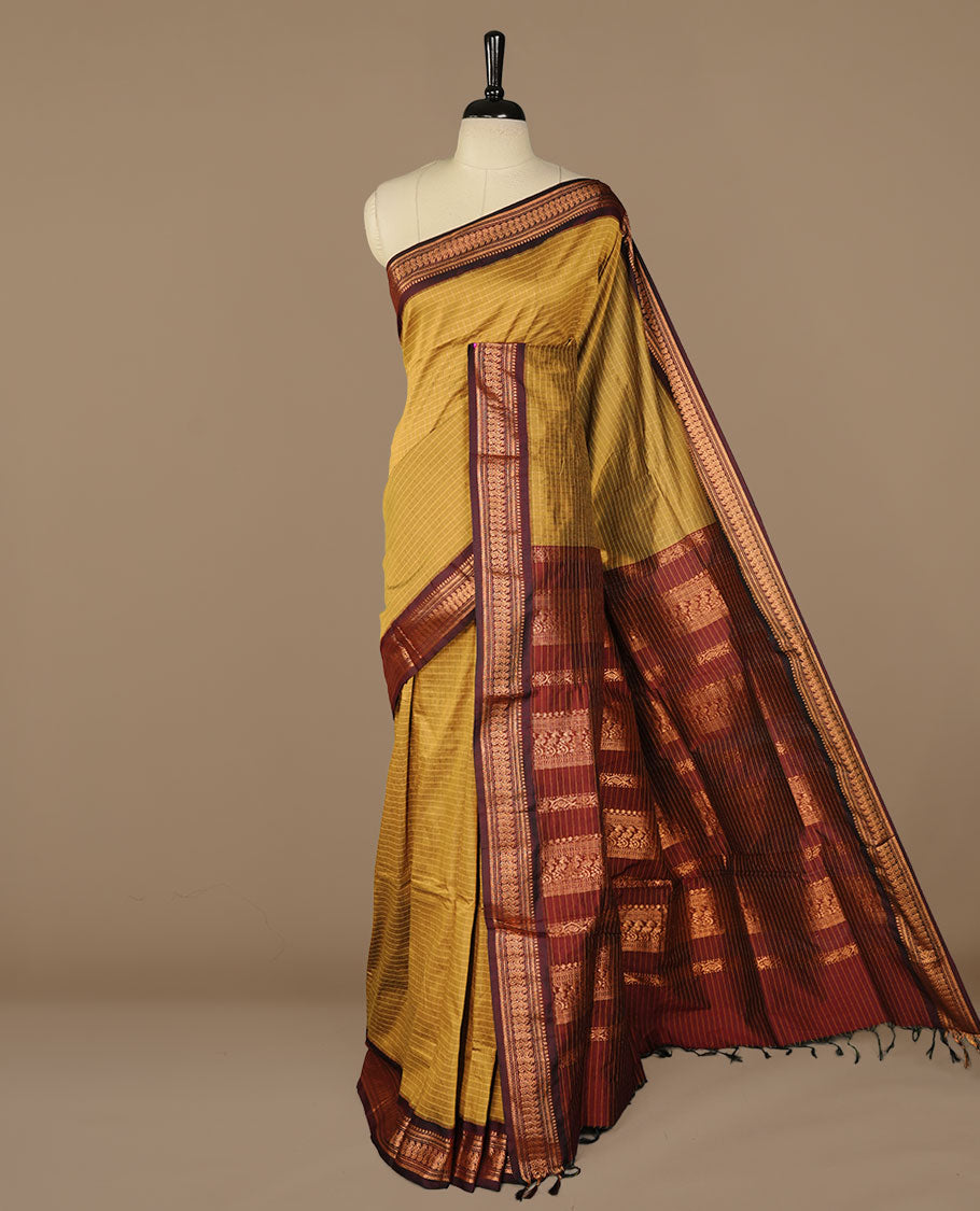 Mustard colour kalyani cotton saree featuring gold zari check pattern on body, complemented by Maroon colour with Antique zari border, paired with matching blouse piece.