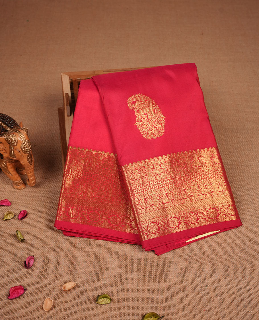 Vibrant red colour pure traditional Kancheepuram silk saree adorned with an elegant zari elephant motif on the body, complemented by a rich gold zari woven border featuring intricate traditional designs, paired with a matching blouse piece.