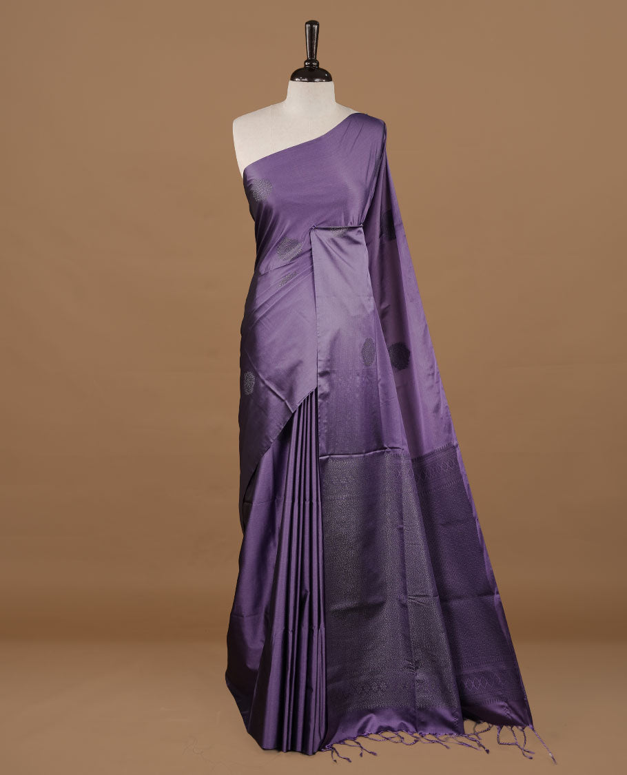 Lavender soft silk saree features a sleek borderless design with intricate antique zari motifs, flowing into a seamless self colored pallu and a matching blouse piece.