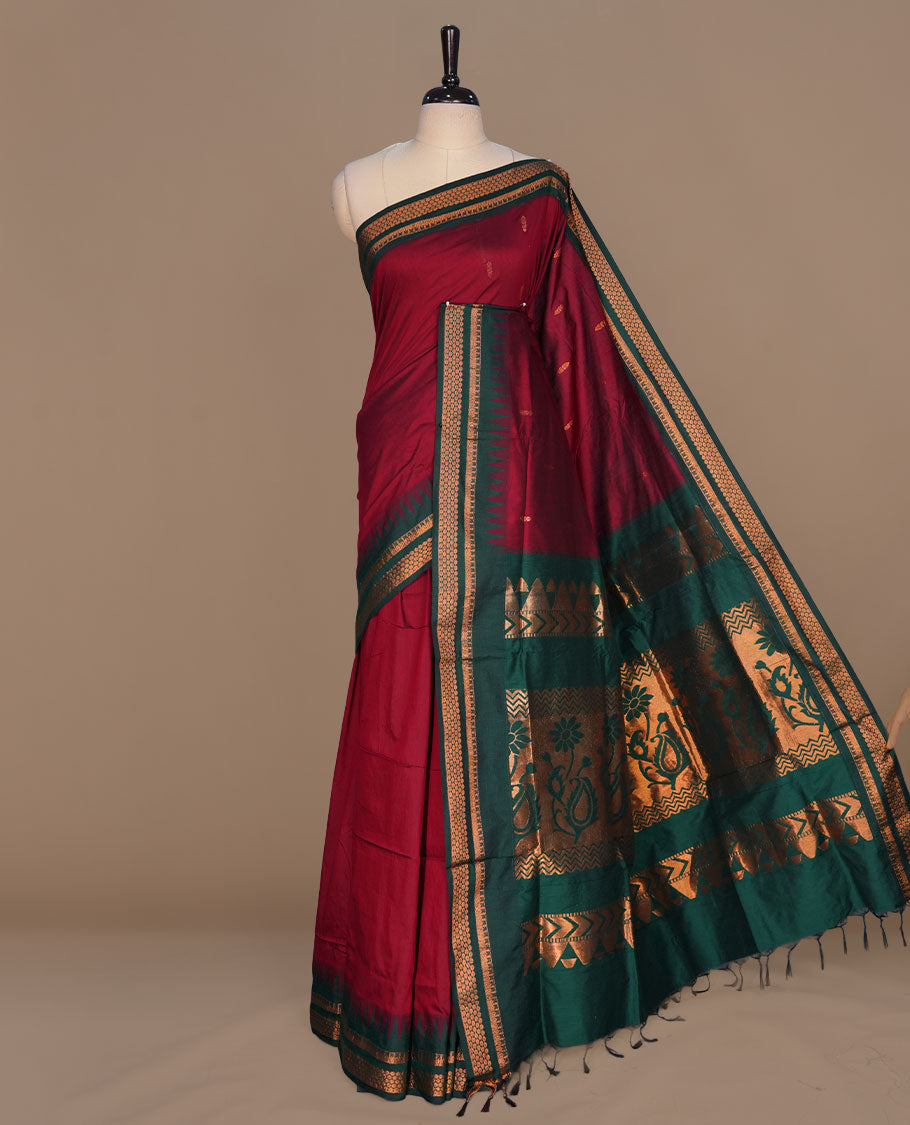 Maroon colour kalyani cotton saree featuring gold zari motifs on body, complemented by contrast maroon color with gold zari pattern border , paired with matching blouse piece.
