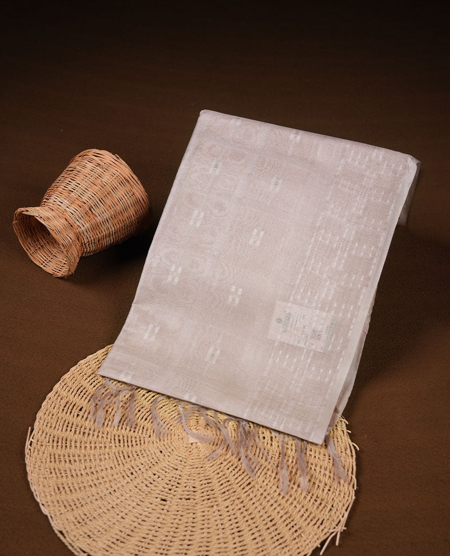 Cream colour semi jute saree highlighting white thread motifs on body, without border and paired with matching blouse.