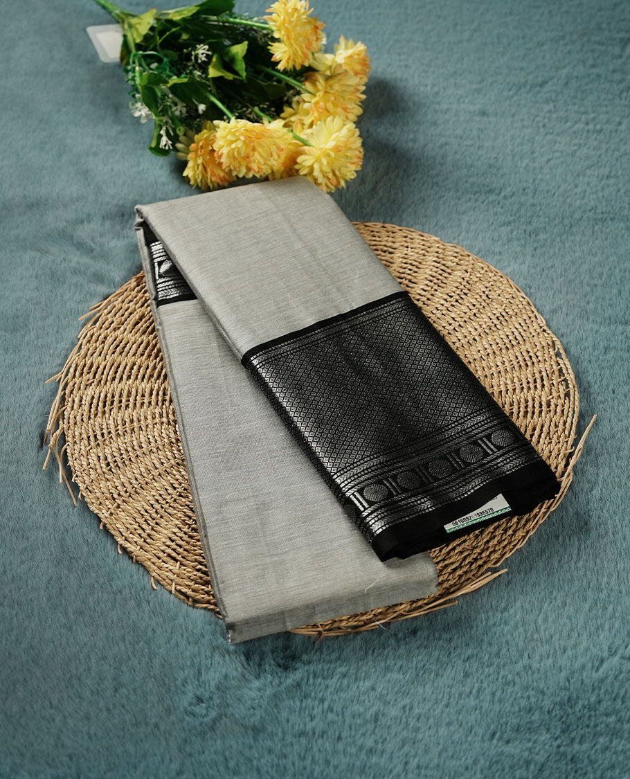 Gray colour Narayanapattu cotton saree featuring a self coloured body, contrast Black colour with silver zari border and pallu, pairing a matching blouse piece.