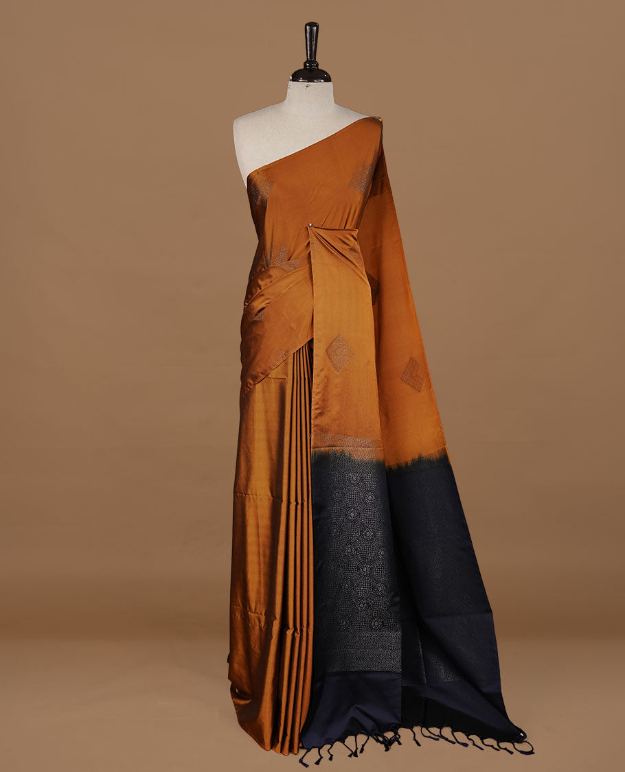 Mustard colour soft silk saree features a sleek borderless design with intricate antique zari motifs, flowing into a striking contrast blue pallu and a matching blouse piece.