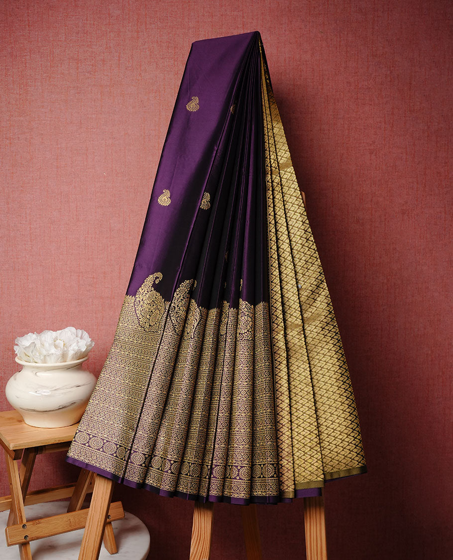 Purple colour soft silk sareee featuring rose gold zari motifs on body, complemented by self colour with zari border, contrast green pallu paired with matching blouse piece.