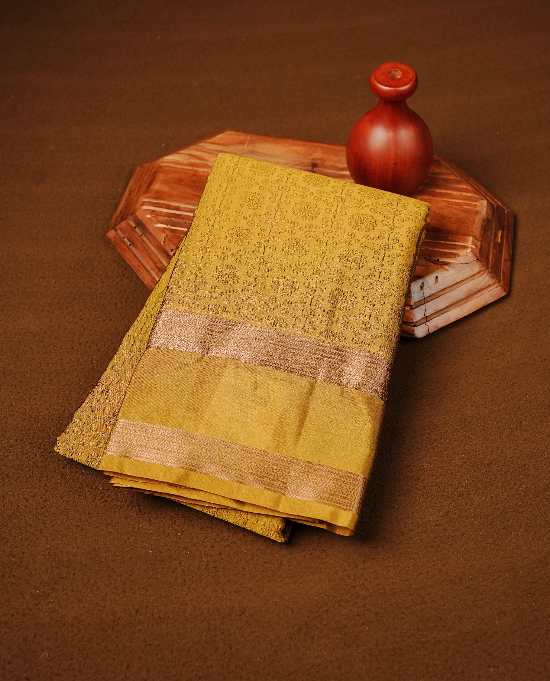 Mustard Yellow Colour Semi Soft Slik Saree Featuring An Elegant Self Floral Woven Body, Enhanced By A Traditional Rose Gold Zari Border And Rich Pallu, Paired With A Matching Blouse Piece.