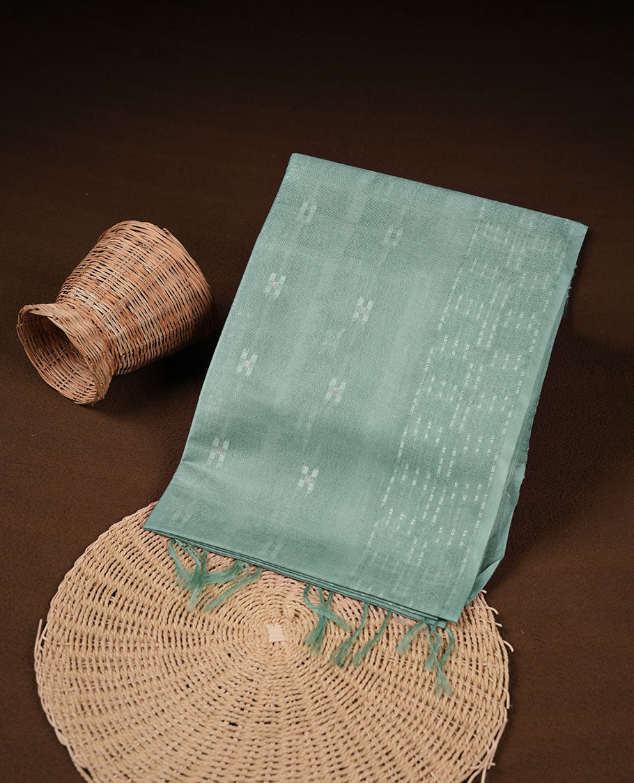 Mint colour semi jute saree highlighting white thread motifs on body, without border and paired with matching blouse.