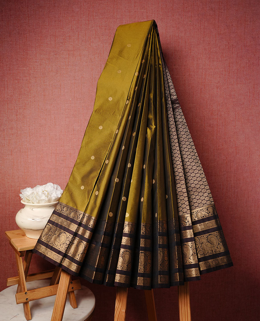 Olive colour soft silk saree featuring Gold zari motifs on body, complemented by contrast chocolate colour with traditional border, paired with matching blouse piece.