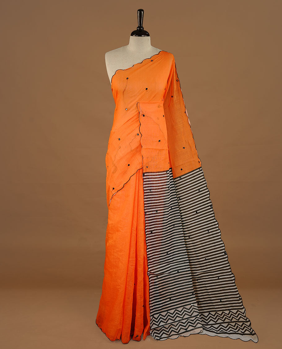 Orange colour Semi Linen saree featuring mirror work with intricate thread detailing, enhanced by a stylish scallop border. Comes without a blouse piece.