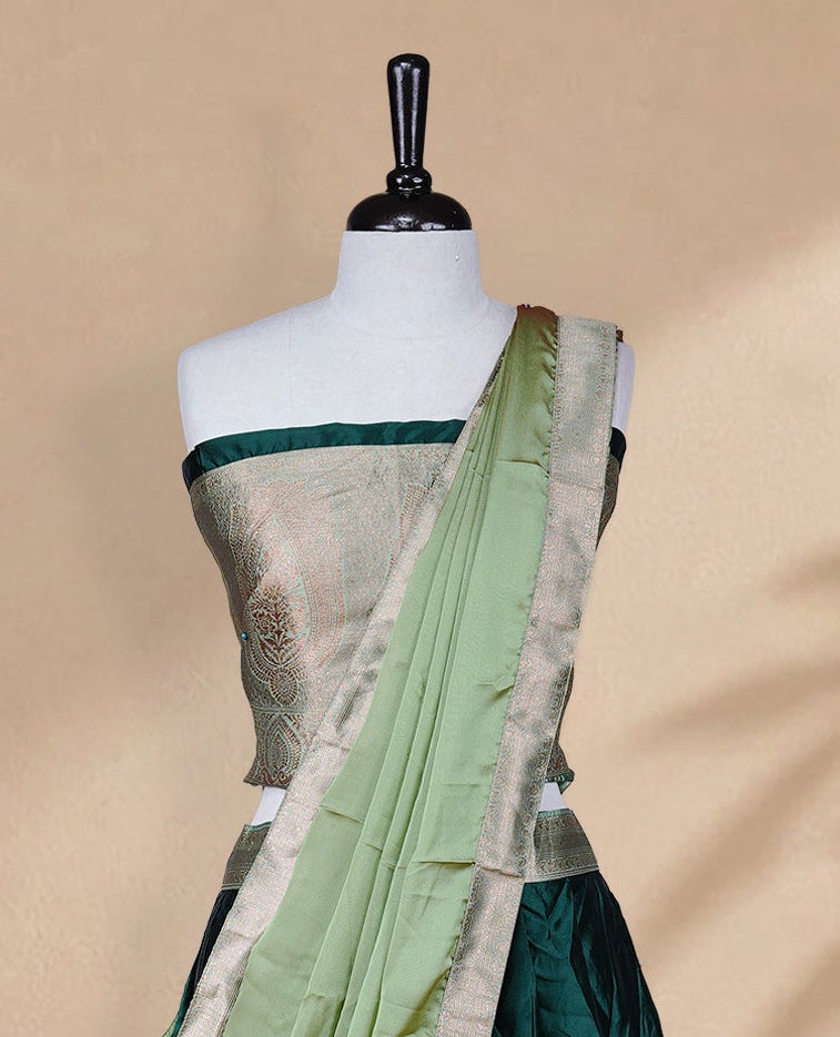 Green colour Half saree featuring Plain skirt with Zari border on contrast Light green colour border, Unstitched Blouse and matching dupatta.