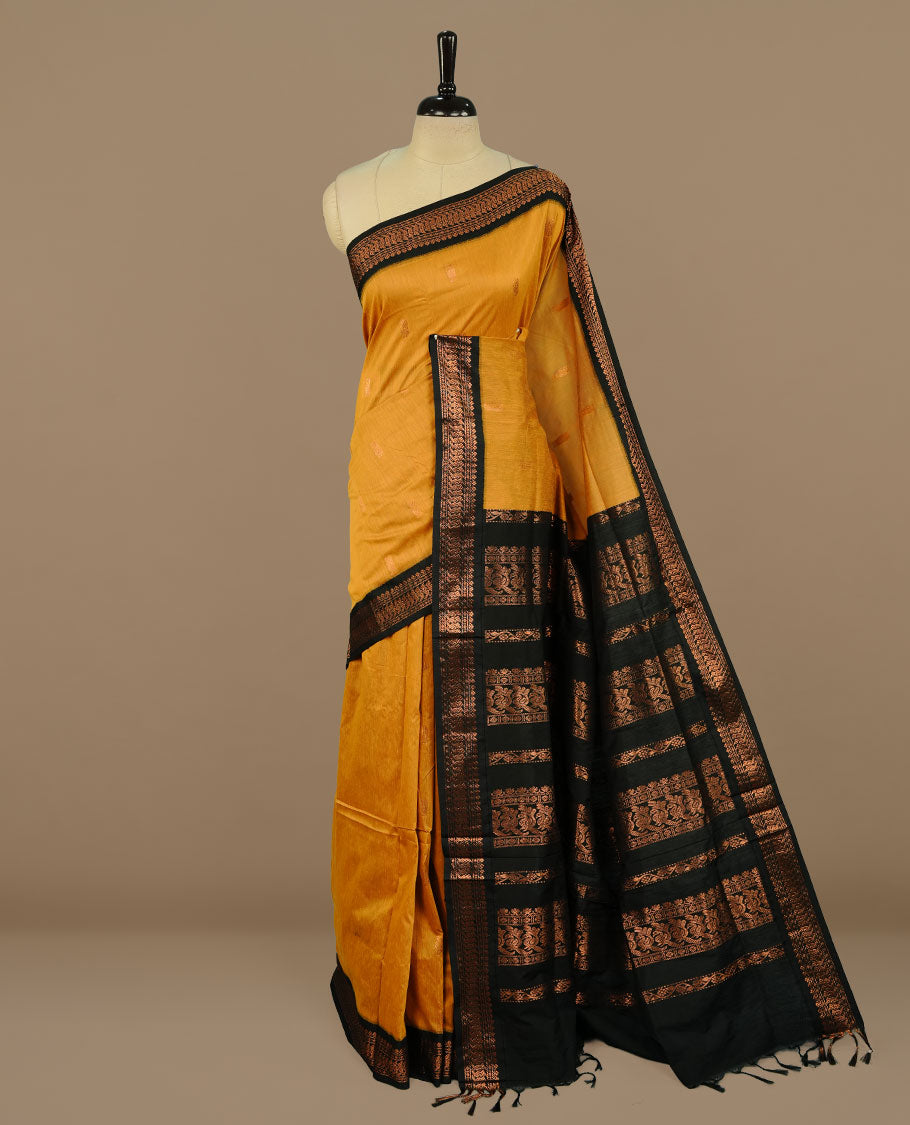 Mustard colour kalyani cotton saree featuring Elegant plain body, complemented by Black colour with Antique zari border, paired with matching blouse piece.