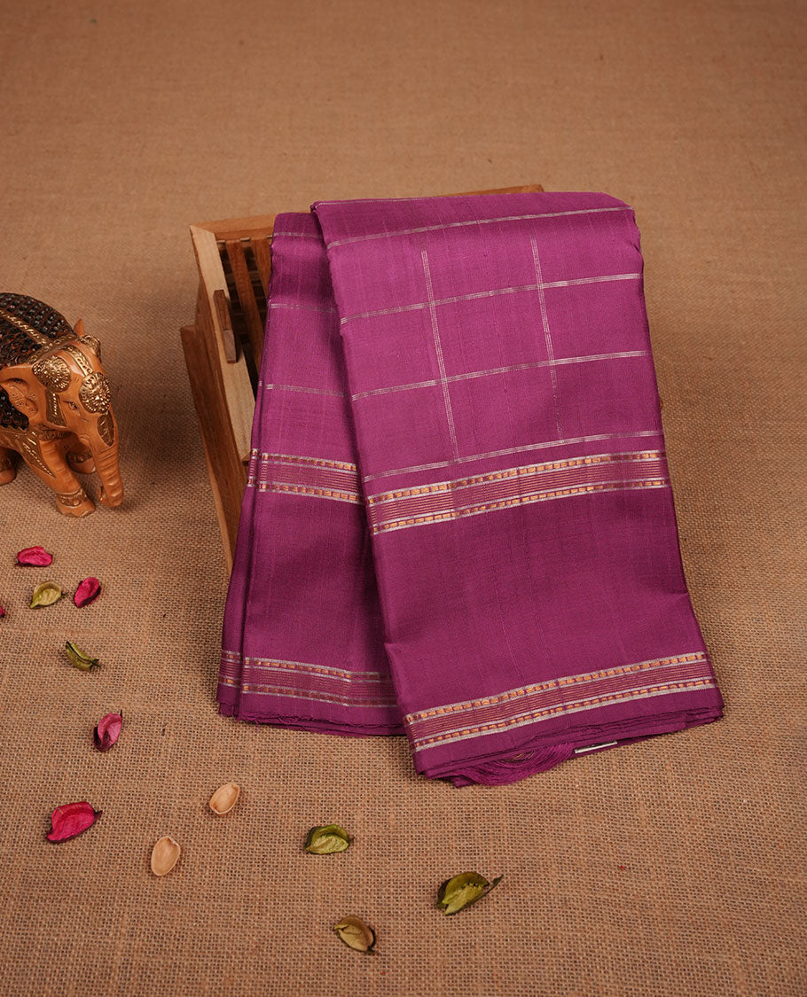 Twilight Magenta colour pure traditional Kancheepuram silk saree adorned with an elegant zari check pattern across the body, complemented by a simple zari woven border, paired with a matching blouse piece.