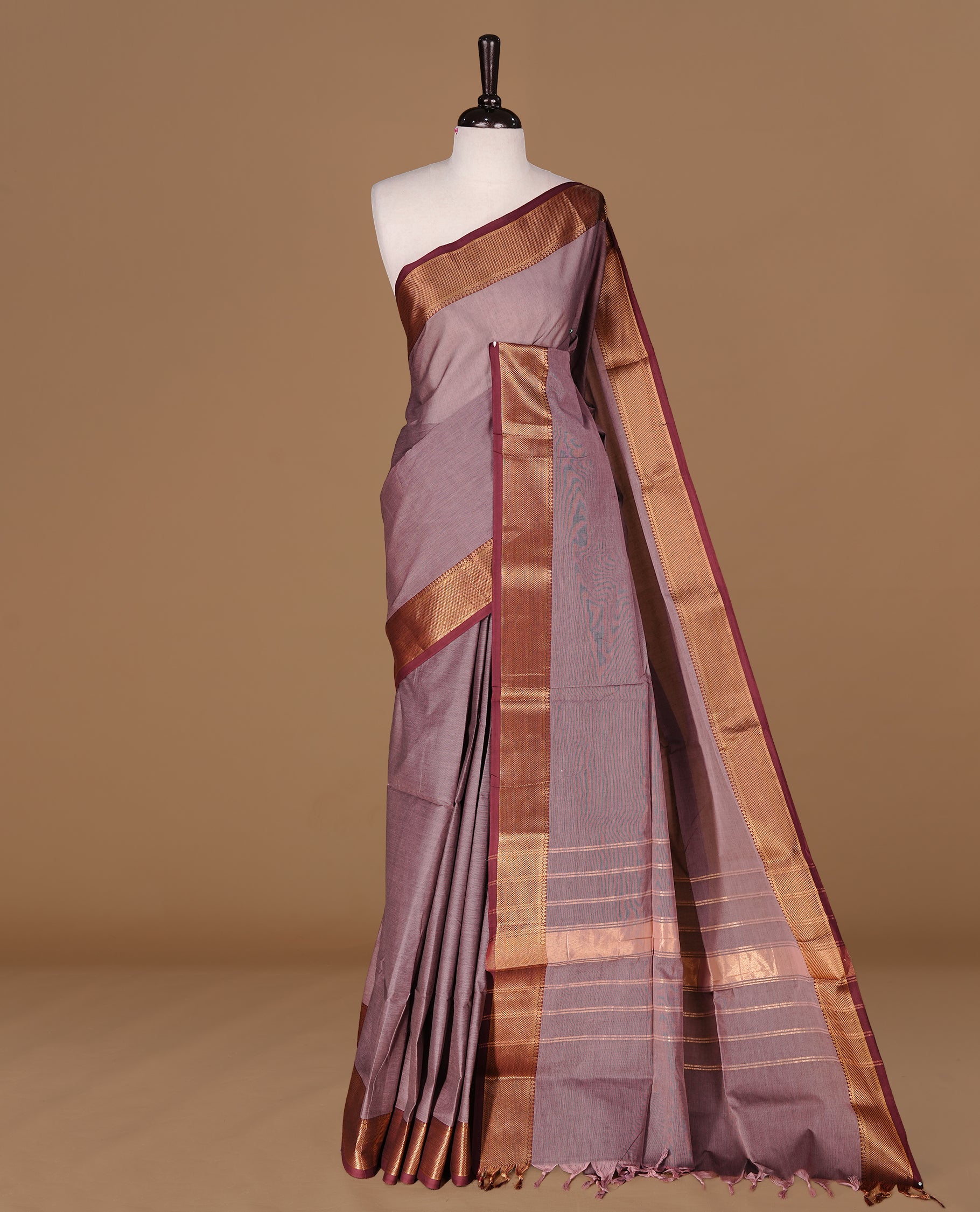 Bronze colour Chettinad Cotton saree featuring elegant plain body, complemented by contrast maroon colour with gold zari border, paired with matching blouse piece.