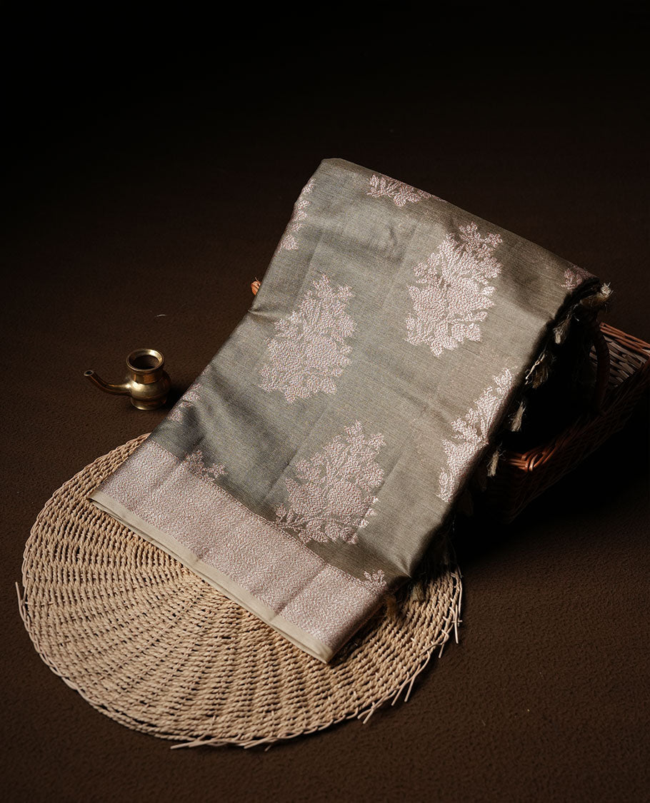 Dry olive colour pure banaras tusser silk saree highlighting antique zari pattern across body, with contrast cream colour with zari border and paired with matching blouse