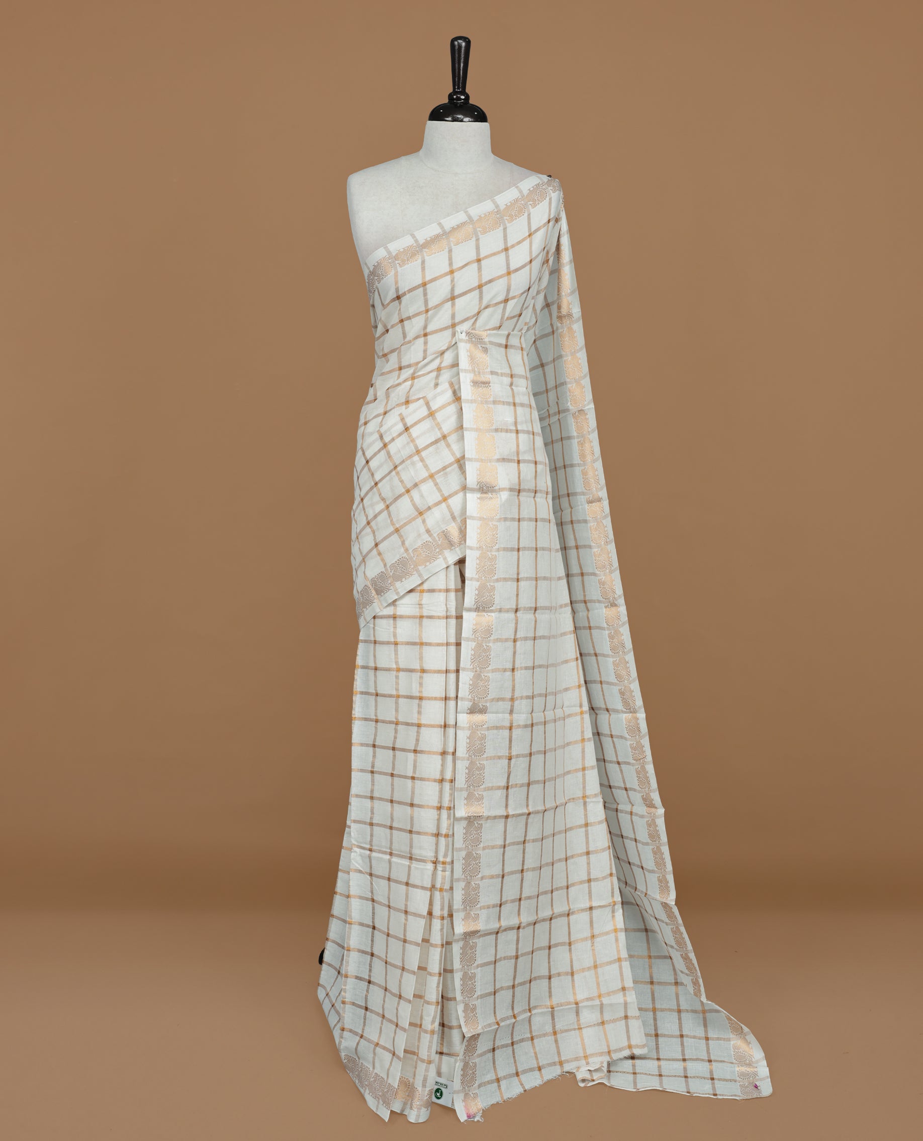 Off white colour Sungudi cotton saree featuring Gold zari checks on body, Gold zari Peacock design on Self colour border, paired with matching blouse piece.