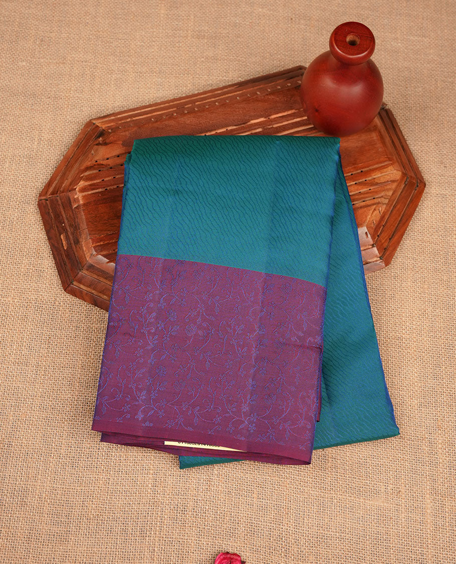 Peacock blue colour soft silk saree featuring zari pattern on body, complemented by a contrast purple zari patterned body, paired with matching blouse piece.
