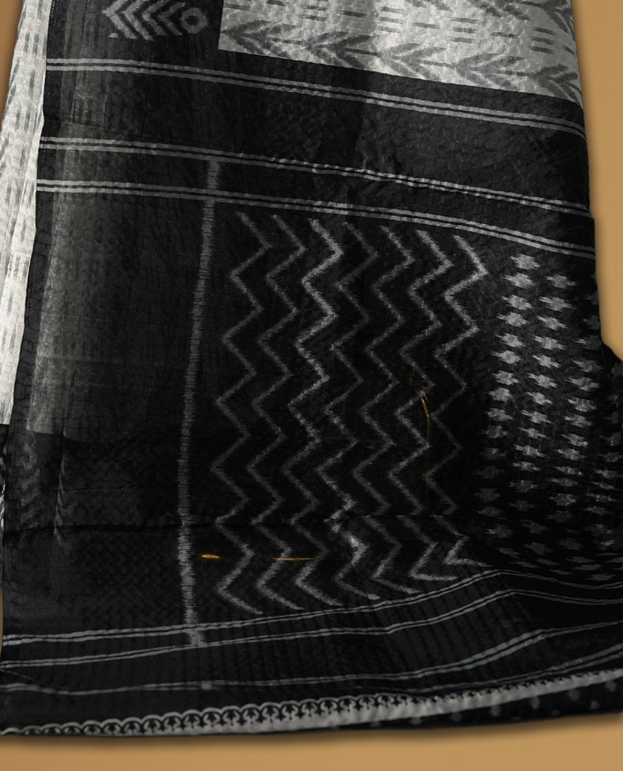 Classic off white colour saree adorned with intricate black tribal motifs and rich woven patterns on the pallu and border & Paired with matching blouse.