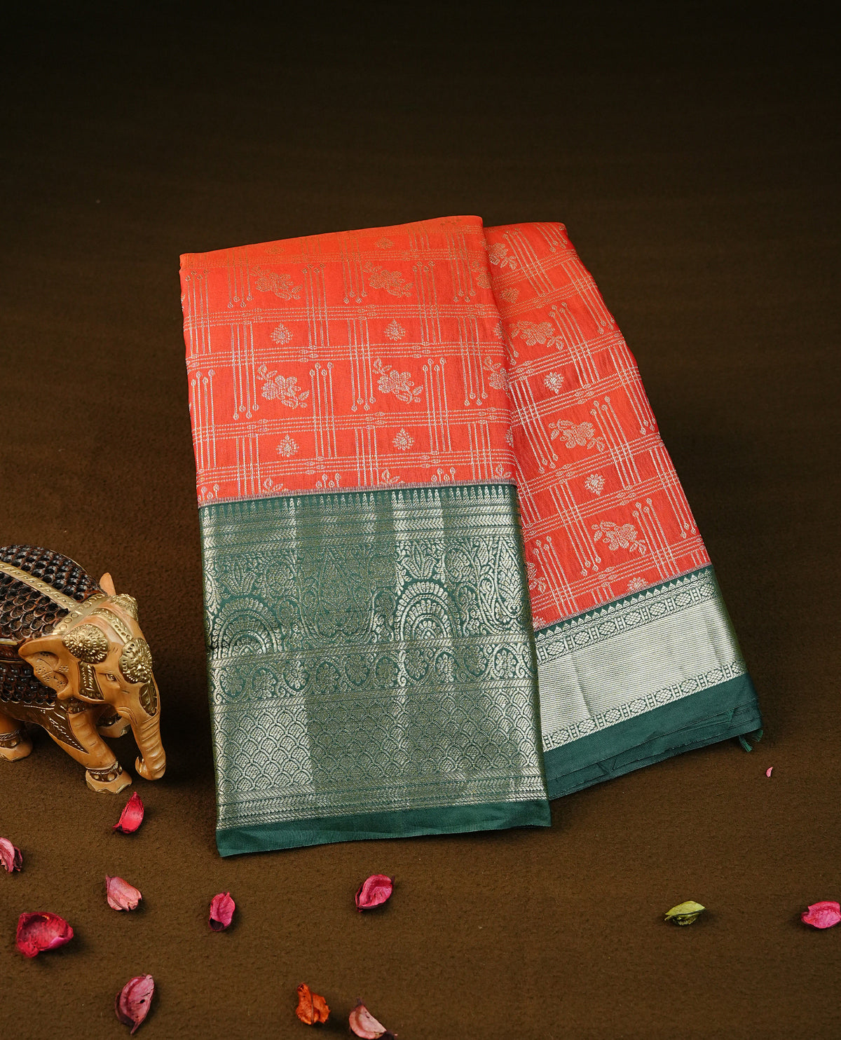 Reddish orange colour semi wedding silk saree featuring gold zari checks with motifs on body,contrast green colour with traditional border on body,rich pallu comes with matching blouse piece