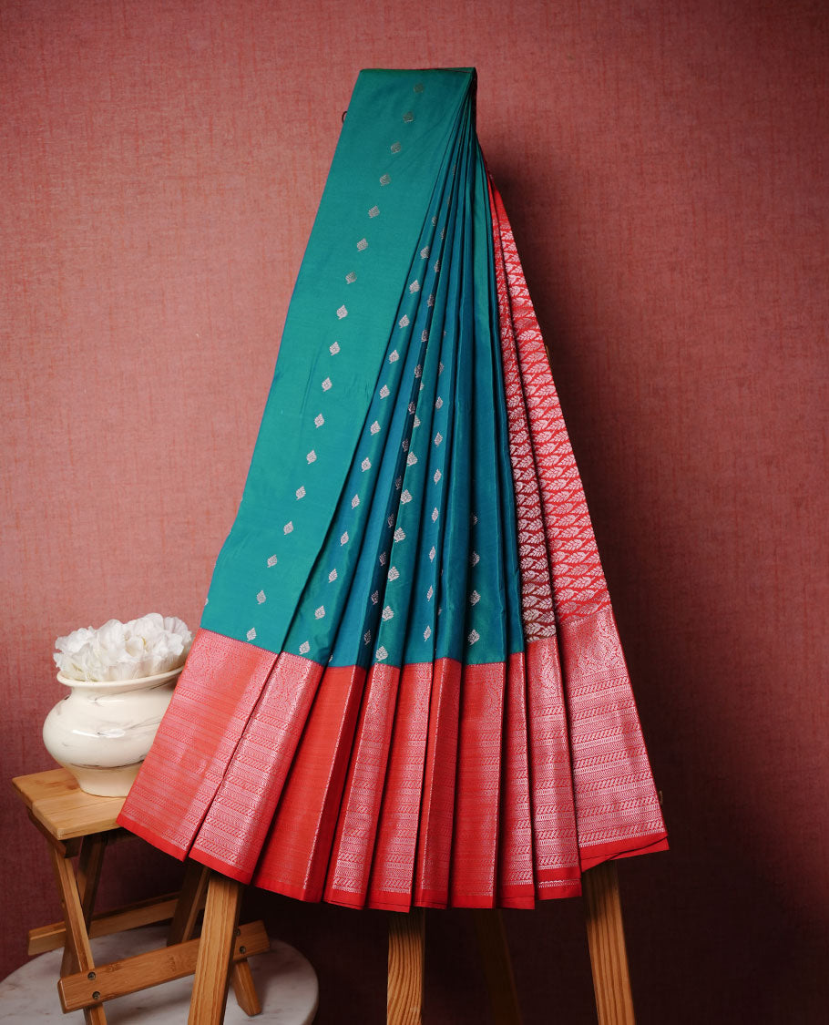 Peacock colour soft silk saree featuring Gold zari motifs on body, complemented by contrast red colour with traditional border, paired with matching blouse piece.