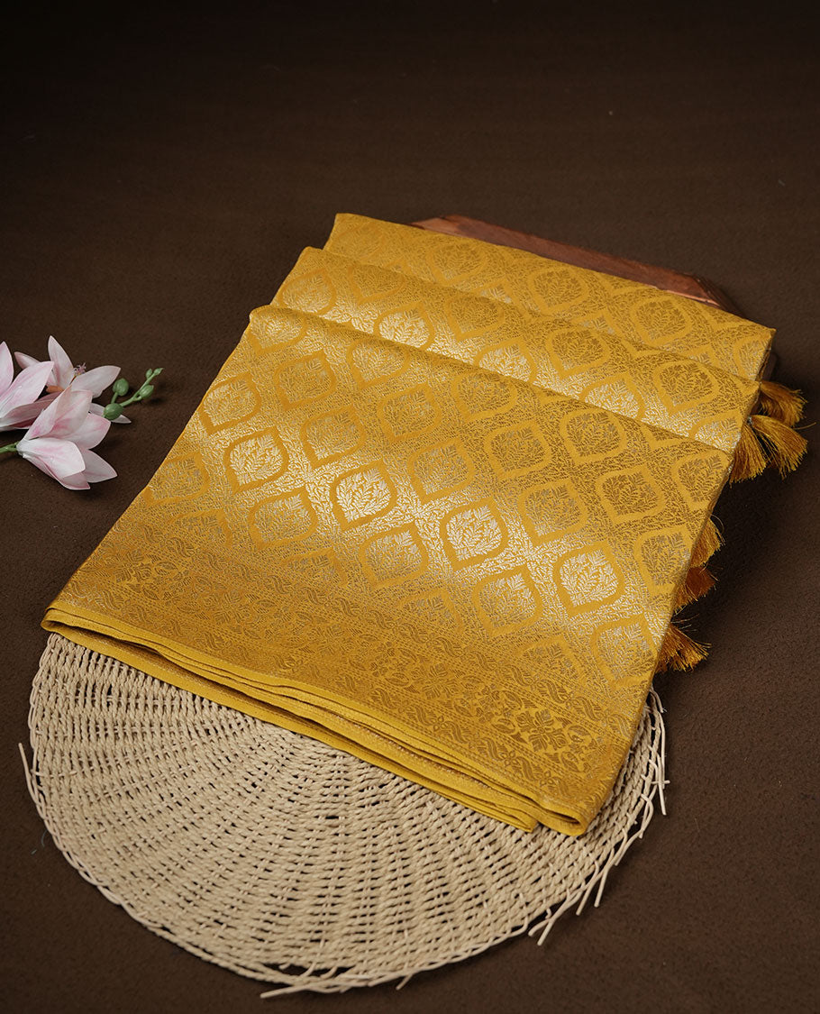 Yellow colour banaras satin crepe saree featuring gold zari pattern across body, with self colour border with gold zari pattern and paired with matching blouse.