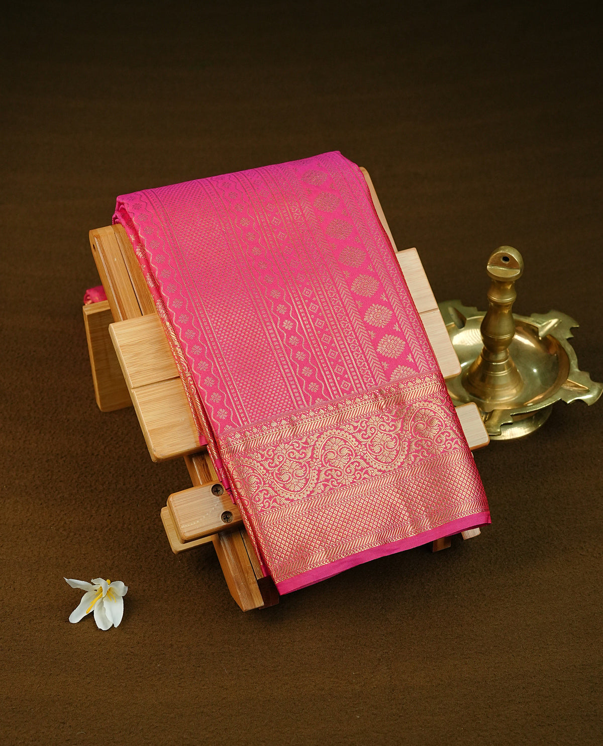 Magenta colour semi wedding saree featuring light gold zari woven strips pattern across the body, complemented by contrast self colour traditional border. Comes with a matching blouse piece.