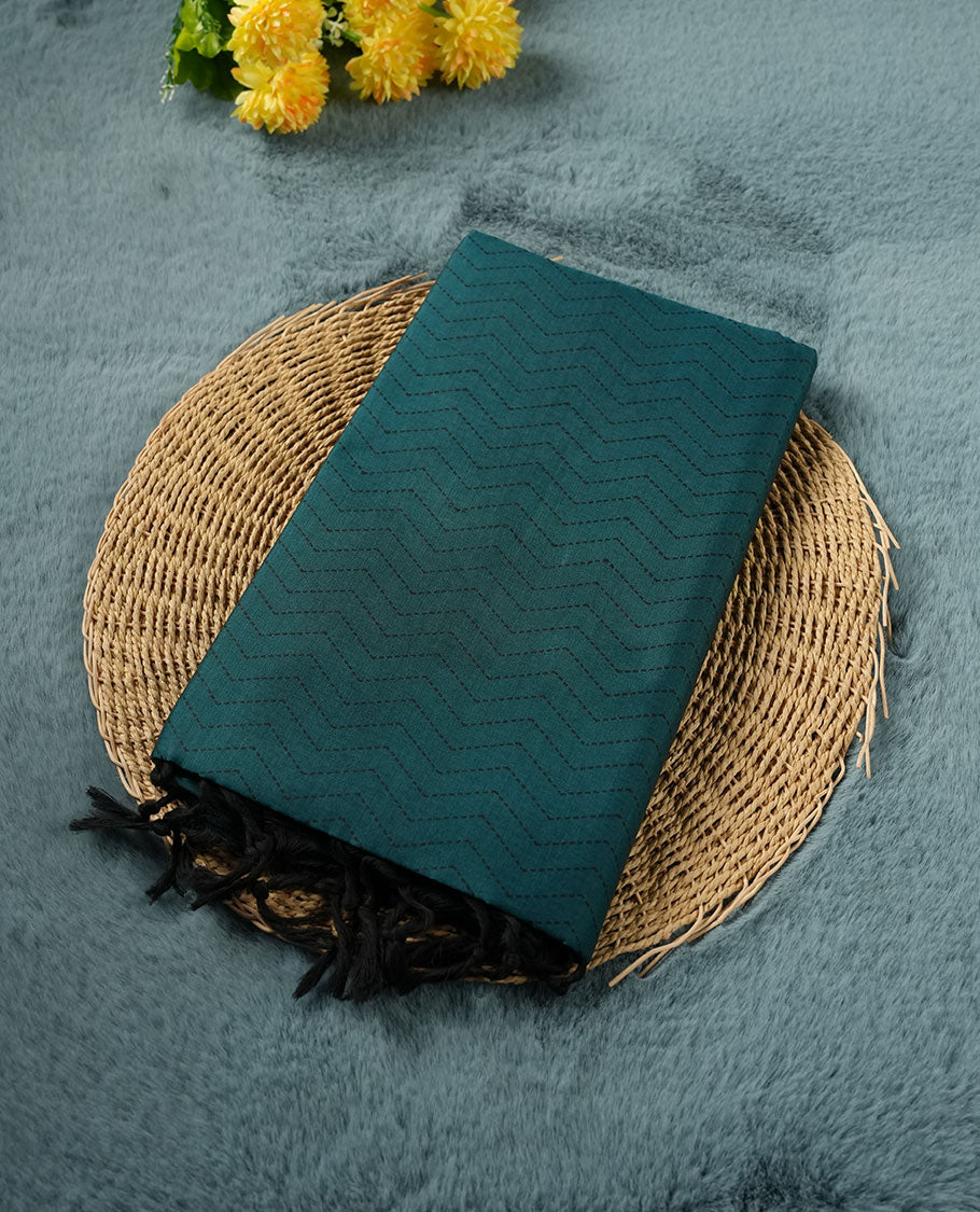 Dark Teal Green colour poly cotton saree with black zigzag line pattern on the body, paired with a matching pallu featuring black chevron lines and panelled floral‑paisley design, and a coordinated all‑over floral paisley patch‑style printed blouse piece.