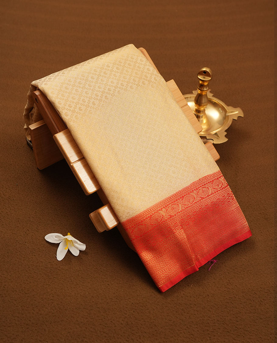 Cream colour semi silk brocade saree featuring intricate Gold Floral in square kodi patterns across the body, complemented by a contrast Red colour woven border and pallu, paired with a matching blouse.
