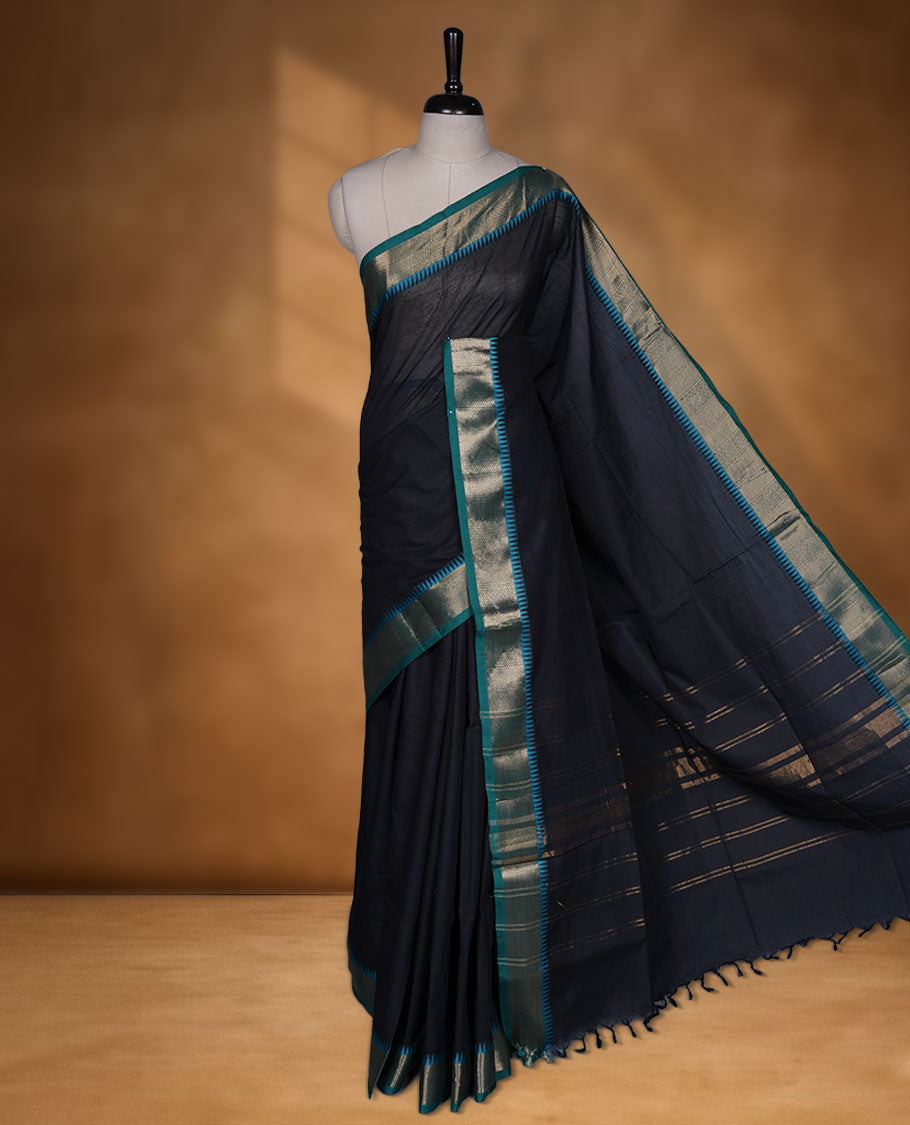Black colour chettinad cotton saree featuring Elegant plain body highlighting contrast green colour colour with gold zari traditional border, pallu and paired with matching blouse piece.