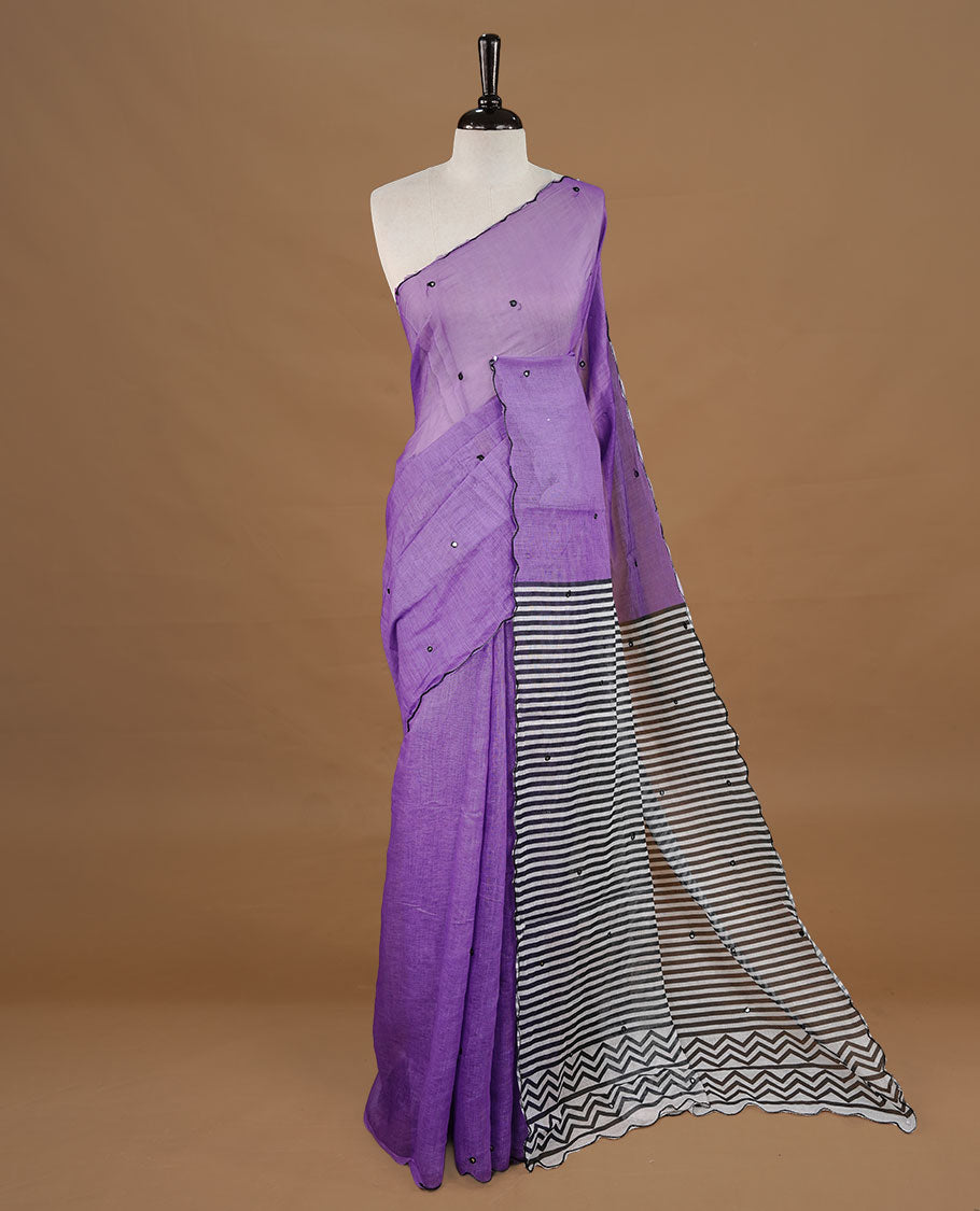 Violet colour Semi Linen saree featuring mirror work with intricate thread detailing, enhanced by a stylish scallop border. Comes without a blouse piece.