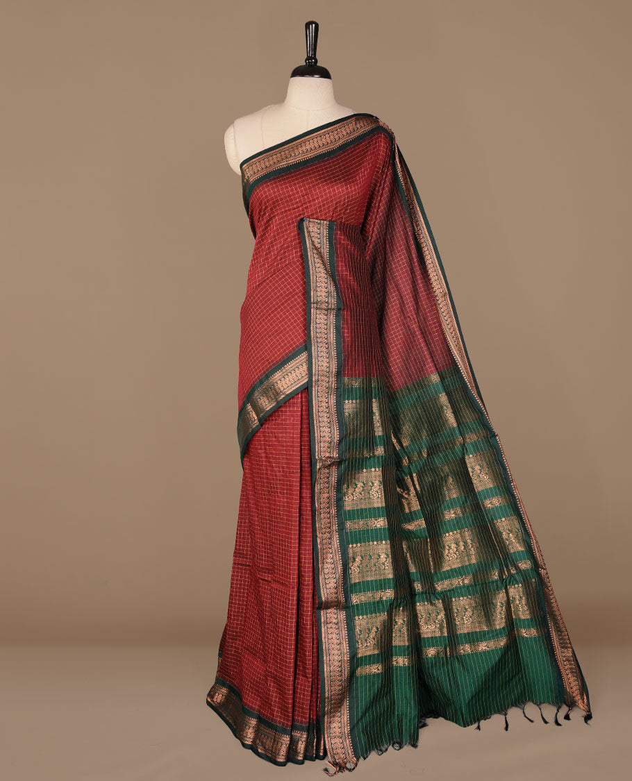 Maroon colour kalyani cotton saree featuring gold zari check pattern on body, complemented by green colour with Antique zari border, paired with matching blouse piece.