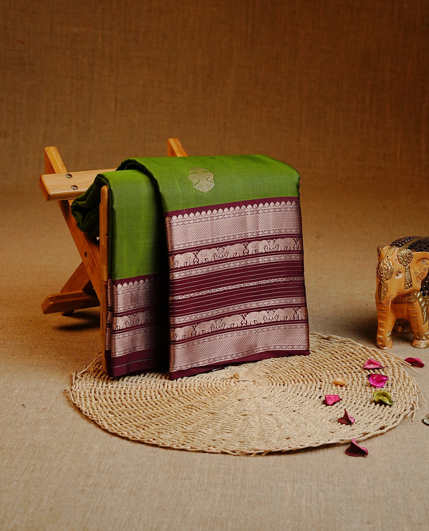 Olive Green Colour Kancheepuram silk saree featuring gold zari motifs on body, highlighting Gold zari Elephant Traditional On contrast Maroon border, paired with Matching blouse piece.