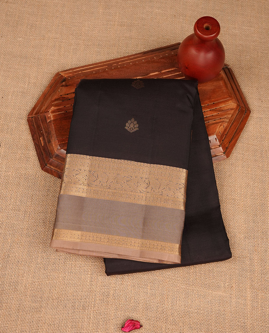 Black colour vasundhara silk saree featuring gold zari buttas on body, complemented by contrast chikku with zari border, paired with matching blouse piece.