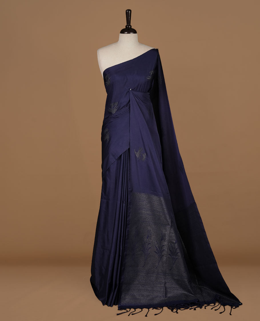 Navy Blue soft silk saree features a sleek borderless design with intricate antique zari motifs, flowing into a seamless self colored pallu and a matching blouse piece.