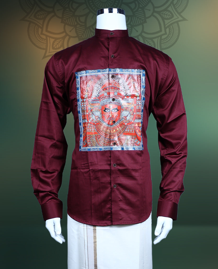 Maroon men’s shirt tailored in a smooth finish, designed with a mandarin collar, full sleeves, and highlighted with an intricate multicolour Theyyam inspired print panel on the front, perfect for festive and cultural wear.