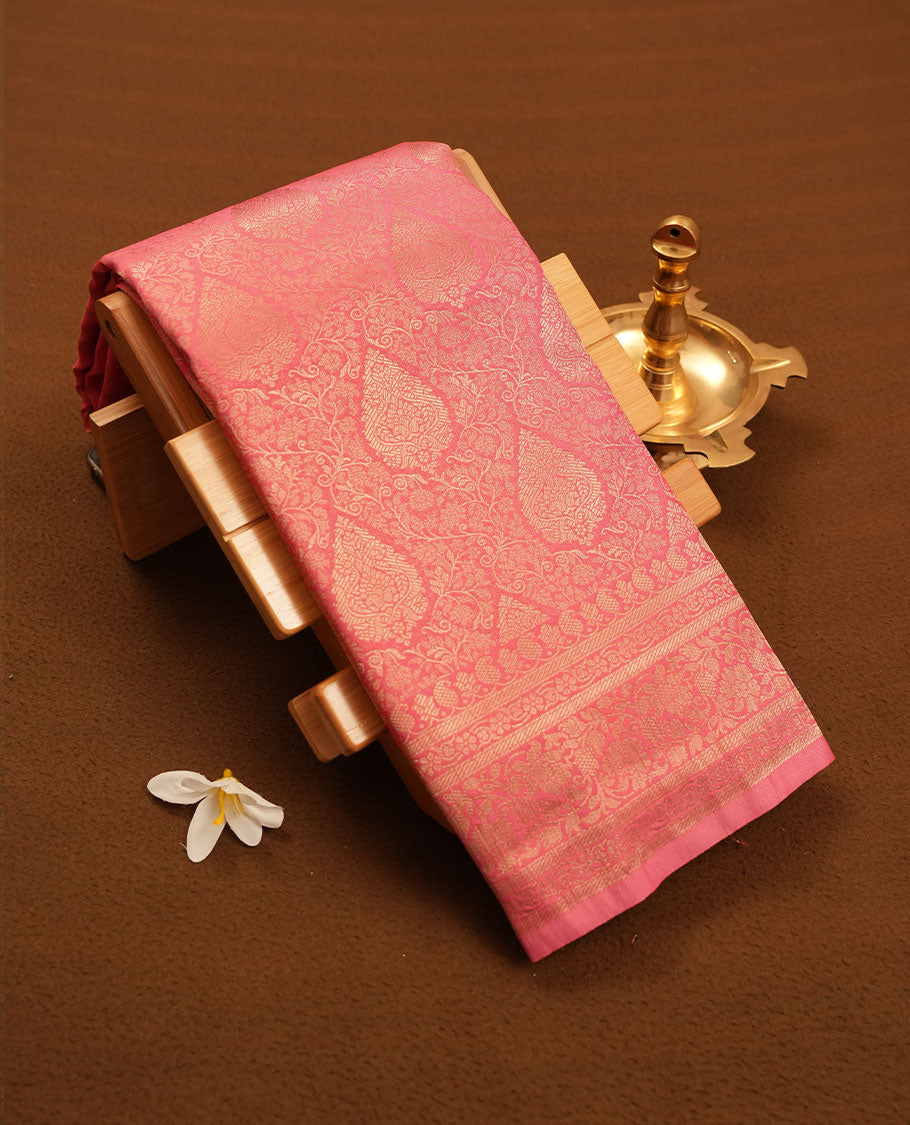 Pink colour semi silk brocade saree featuring intricate Gold Floral kodi patterns across the body, complemented by a self colour woven border and pallu, paired with a matching blouse.