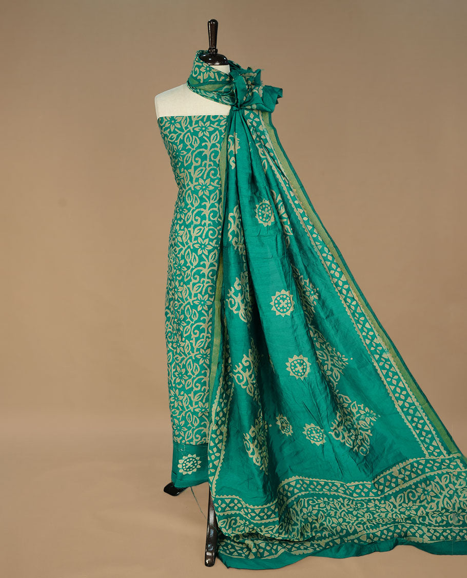 Green colour salwar suit matieral featuring cream colour floral kodi printed on body, paired with matching bottom and dupatta.