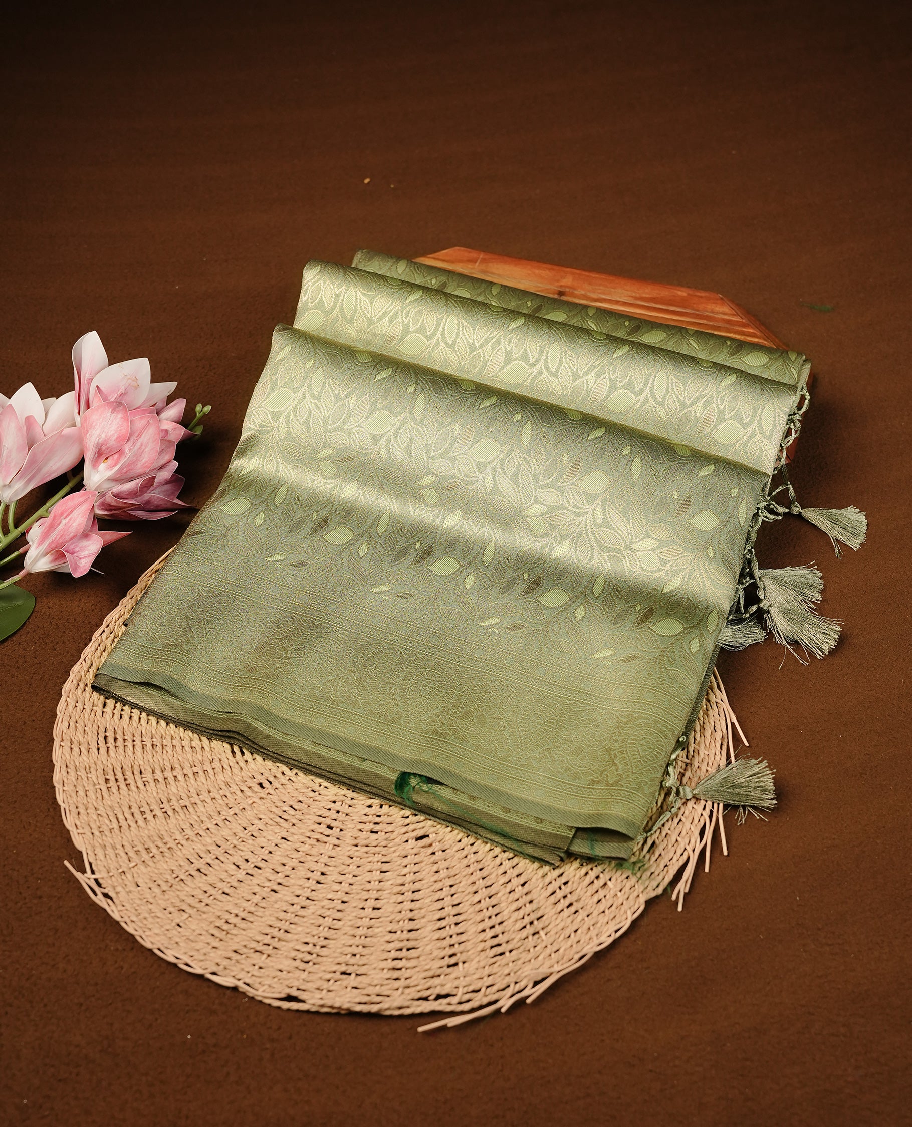 Pistachio Colour Softie Silk Saree Featuring An All Over Gold Woven Leaf Pattern, Finished With A Matching Border Adorned With Intricate Paisley And Floral Motifs, Paired With A Matching Blouse Piece.