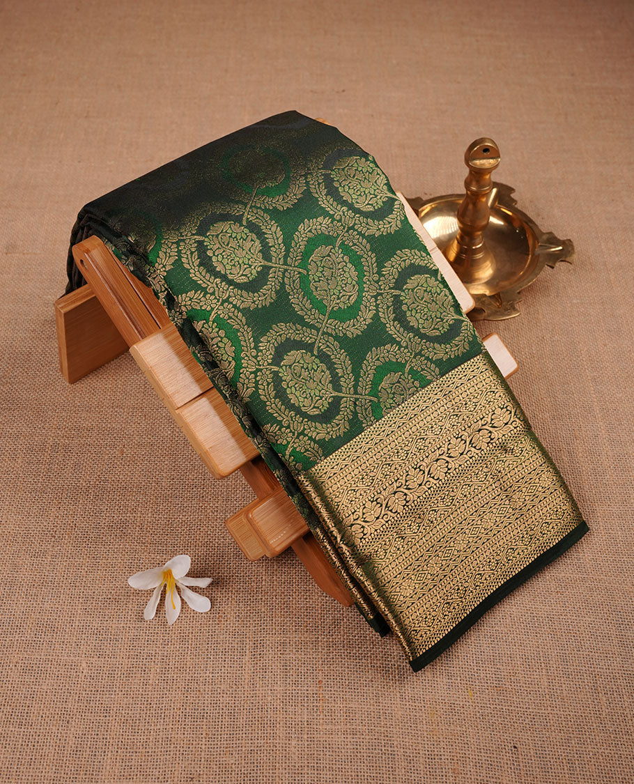 Bottle green colour kancheepuram silk sare featuring banaras floral zari jacquard on body with traditional border, paired iwth matching blouse piece.
