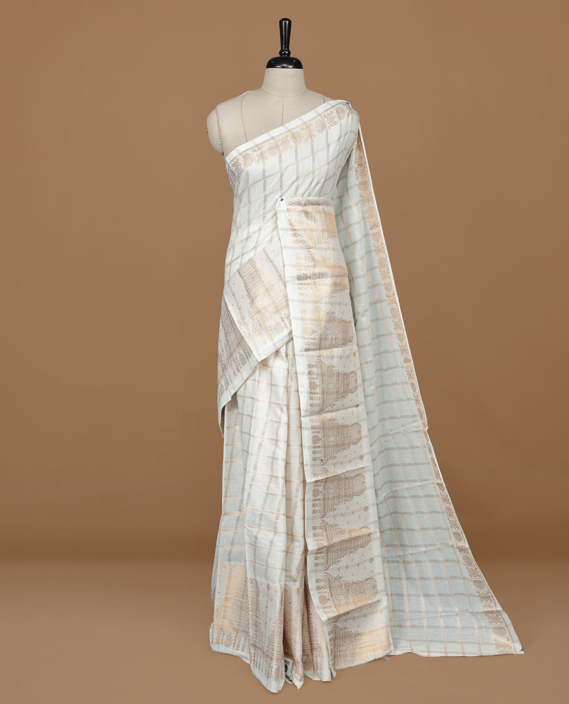 Off white colour Sungudi cotton saree featuring Gold zari checks on body, Gold zari temple design on Self colour border, paired with matching blouse piece.