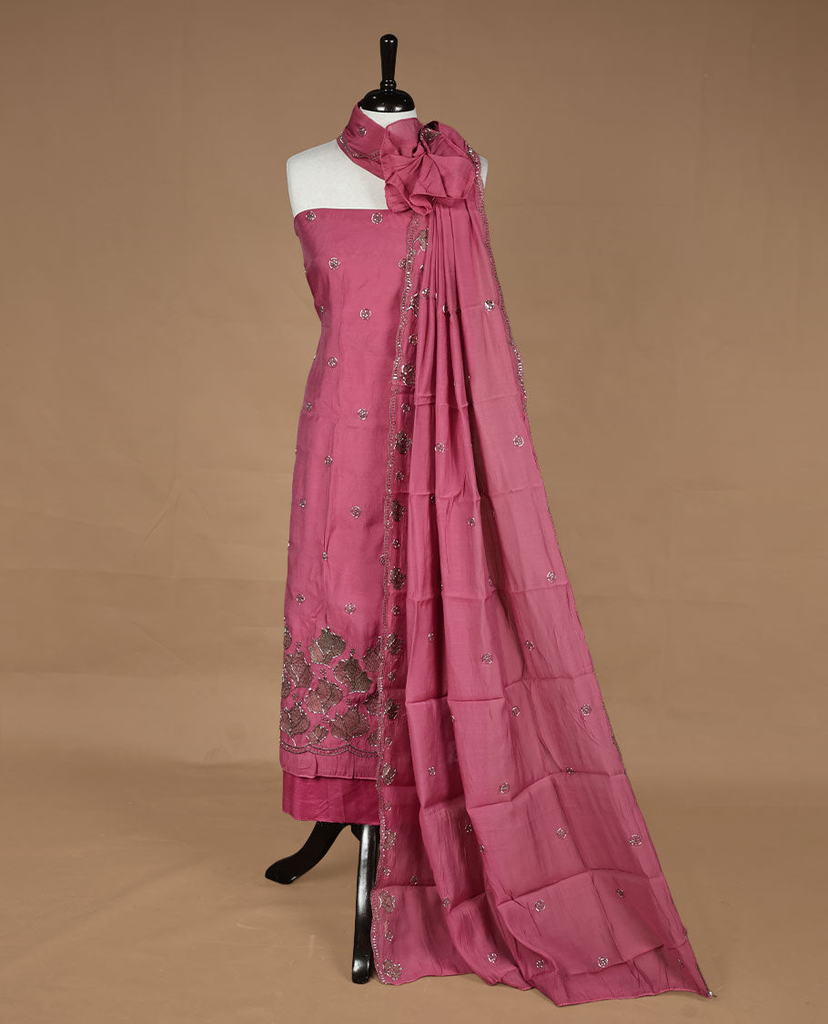 Pink colour churidar material featuring floral cut beats and thread work on body, paired with matching bottom and dupatta.