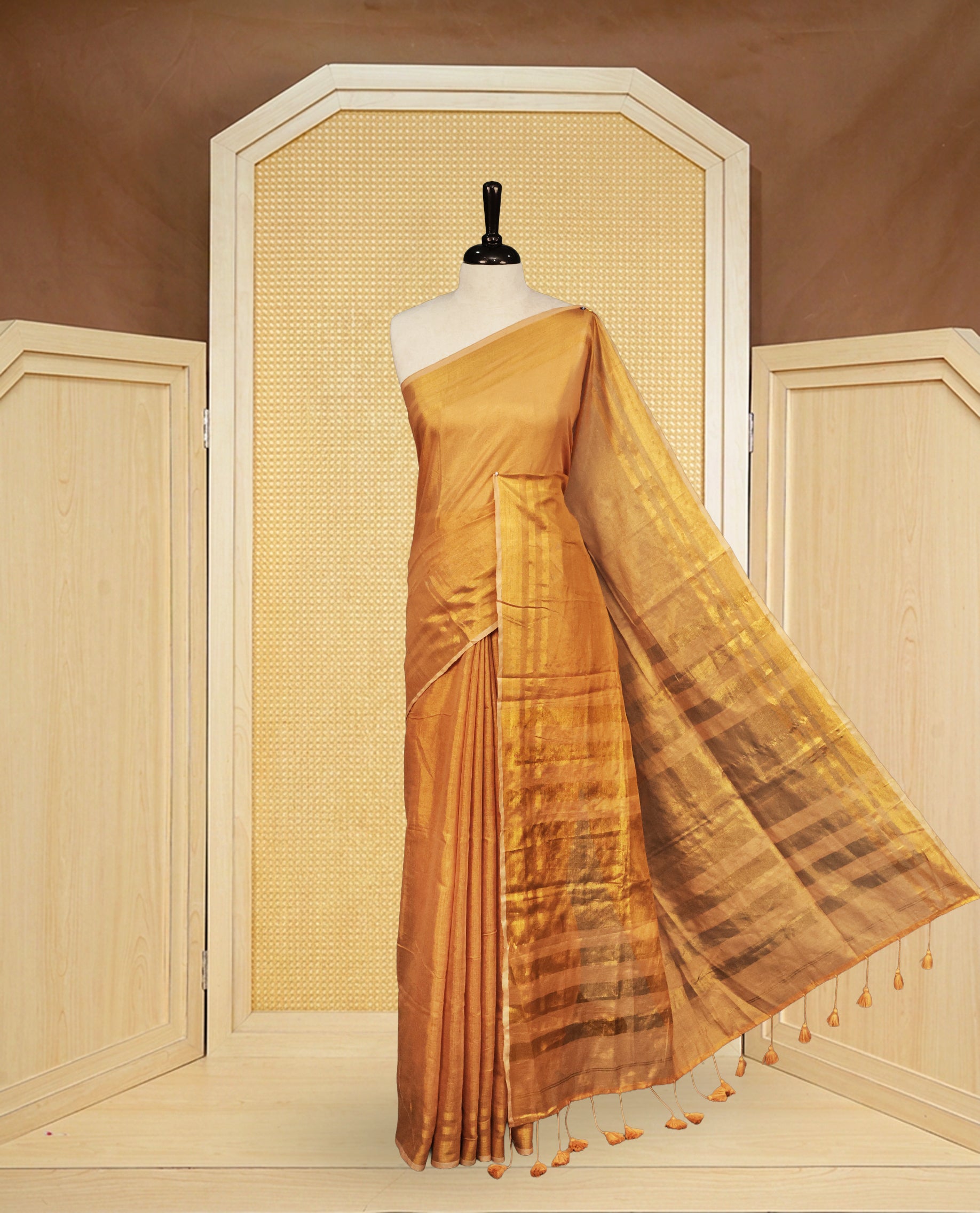 Gold colour Semi Tissue Silk saree featuring Elegant plain body, Enhanced with Gold tissue Border & Striped Pallu & beautiful Tassels for Elegant Prefect Look.