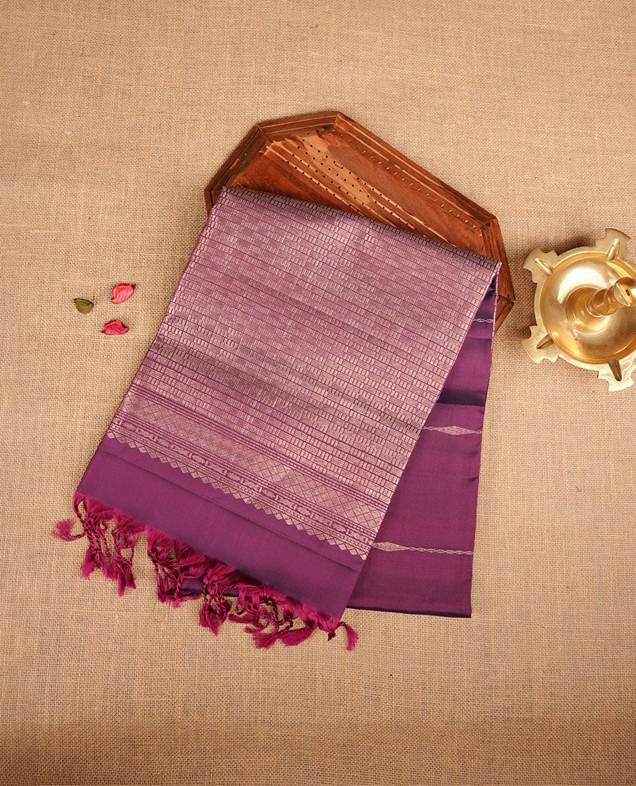 Purple colour soft silk saree featuring gold zari motifs on body, complemented by self colour with traditional border with tassel at pallu, paired with matching blouse piece.