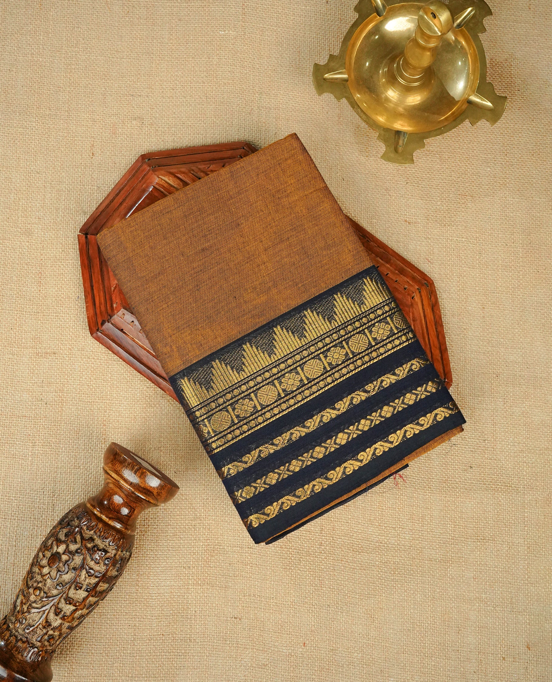 Mustard colour chettinad cotton saree featuring elegant plain body, complemented by contrast Black colour with gold zari border, comes with matching blouse piece.