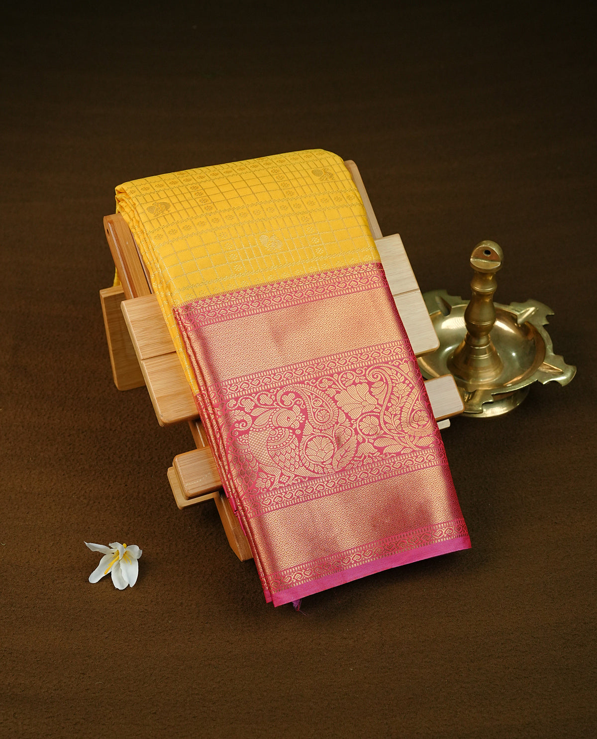 Yellow colour semi wedding saree featuring gold zari check with peacocok motifs on body complemented by contrast magenta colour with traditional border, comes with macthing blouse piece.